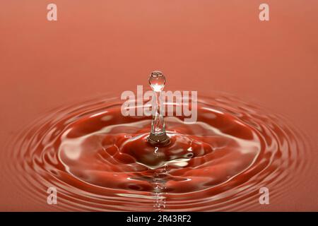 La goutte d'eau tombe à la surface de l'eau Banque D'Images