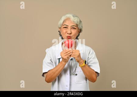 Portrait d'une femme médecin cardiologue tenant un cœur rouge. Concept de cardiologie, médecine, don et soins de santé Banque D'Images