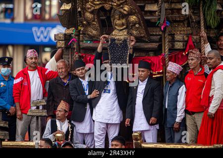 Un membre népalais du Guthi Sansthan présentant le Bhoto noir orné de pierres précieuses du « Dieu de la pluie » Rato Machhindanath au public depuis le char de t. Banque D'Images