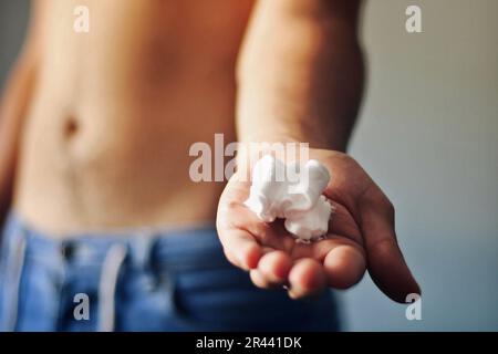 Homme avec de la mousse à raser dans sa main. Banque D'Images