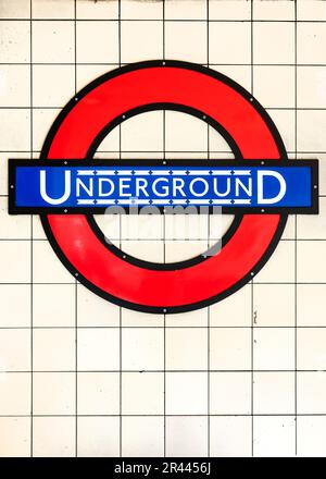 Panneau bleu et rouge souterrain sur fond de carreaux blancs dans une station de métro de Londres, Royaume-Uni Banque D'Images