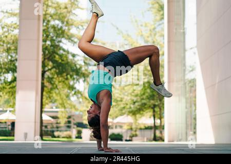 présentation d'une femme brunette faisant de la capoeira dans les rues Banque D'Images