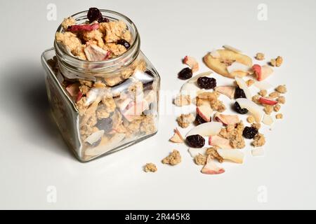 Délicieux muesli petit déjeuner avec noix de coco séchées, banane, pomme, canneberges et raisins secs. Banque D'Images