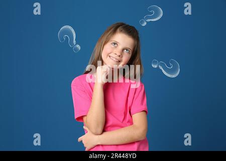Choix dans la profession ou dans d'autres domaines de la vie, concept. Prendre la décision, jolie jeune fille de préadolescence entourée de points d'interrogation dessinés sur fond bleu Banque D'Images