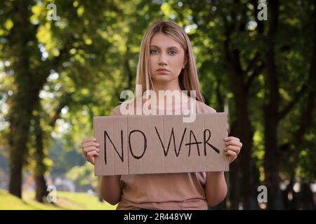 Triste femme tenant une affiche avec des mots No War dans le parc Banque D'Images