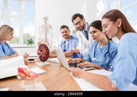 Médecin et stagiaires utilisant un ordinateur portable à l'université Banque D'Images