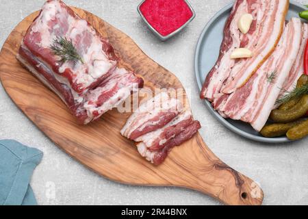 Fatback de porc savoureux avec concombres marinés, ail et aneth sur table grise, plat Banque D'Images