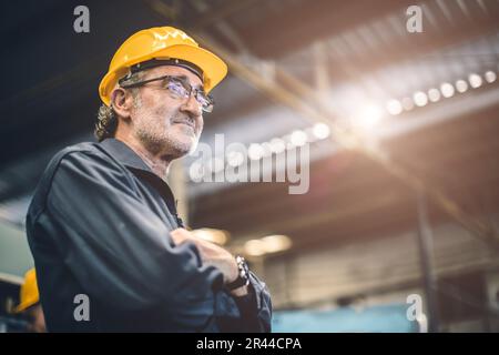 Ingénieur professionnel senior de haut niveau travailleur masculin dans l'usine de l'industrie lourde se tenant confiant. portrait personne âgée en bonne santé travailleur intelligent. Banque D'Images