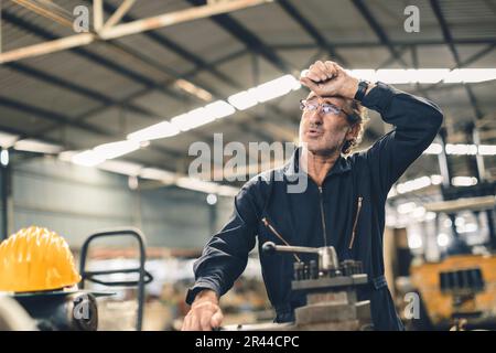 Fatigue sueur adulte senior travailleur dur fatigue homme personnel dans l'usine de métal temps chaud Banque D'Images