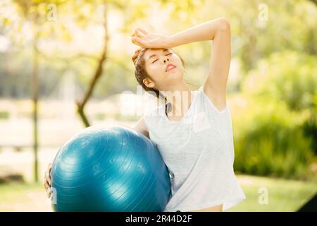 sport femme exercice extérieur sentir mal de tête au-dessus de la chaleur par temps chaud saison d'été Banque D'Images