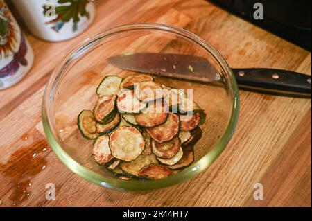 Friture ou brunissage de tranches de courgettes ou de courgettes dans de l'huile de tournesol prête à l'emploi dans un plat de pâtes italien Banque D'Images