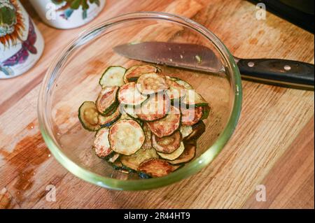 Friture ou brunissage de tranches de courgettes ou de courgettes dans de l'huile de tournesol prête à l'emploi dans un plat de pâtes italien Banque D'Images