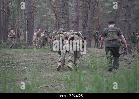 Les soldats de l'infanterie régulière des Forces armées de UkraineÕs reçoivent une formation médicale intensive de la part de bénévoles de la Fondation Prytula. Les formateurs de la fondation apprennent auprès d'experts en formation médicale occidentale de type OTAN au TCCC. Les soldats de la grande base militaire simulent les conditions de première ligne, vivent dans la forêt et creusent des tranchées sur de longues périodes. Banque D'Images