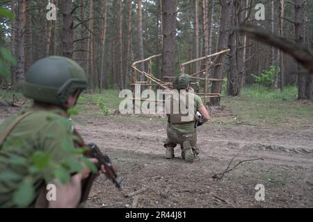 Les soldats de l'infanterie régulière des Forces armées de UkraineÕs reçoivent une formation médicale intensive de la part de bénévoles de la Fondation Prytula. Les formateurs de la fondation apprennent auprès d'experts en formation médicale occidentale de type OTAN au TCCC. Les soldats de la grande base militaire simulent les conditions de première ligne, vivent dans la forêt et creusent des tranchées sur de longues périodes. Banque D'Images