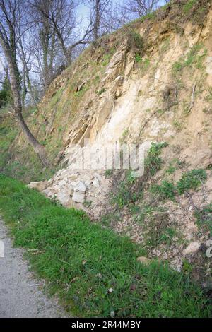 Glissement de terrain à côté de la route de terre le jour ensoleillé à la verticale Banque D'Images