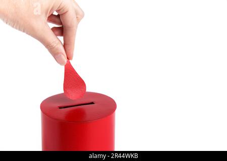 Donneur de sang. La main met une goutte de sang dans la boîte comme don sur fond blanc. Concept donner du sang sauver la vie. Gros plan. Copier l'espace Banque D'Images