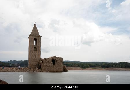 Photographie en exposition longue de l'église de Sant Roma de Sau dans le réservoir de Sau avec de l'eau à effet de soie avec les gens Banque D'Images