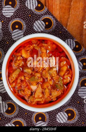 Atchar traditionnel de mangue sud-africaine ou Achar sur tissu imprimé africain avec pelle Banque D'Images