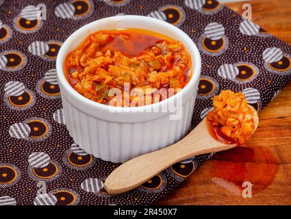 Atchar traditionnel de mangue sud-africaine ou Achar sur tissu imprimé africain avec pelle Banque D'Images