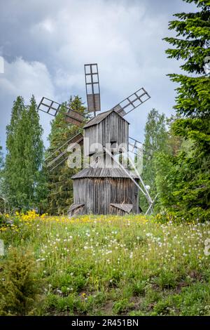 Un moulin à vent ancien, debout sur fond d'herbe verte vibrante dans un paysage rural Banque D'Images