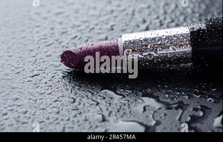 Rouge à lèvres violet en gouttes d'eau Banque D'Images