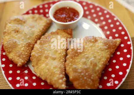 Trois chebureki avec sauce sur l'assiette dans le restaurant Banque D'Images
