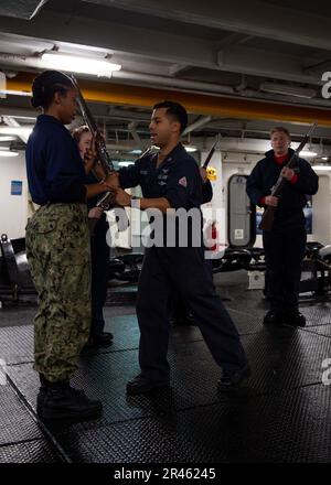 230118-N-TD381-1013 OCÉAN PACIFIQUE (18 janv. 2023) Aviation Boatswain’s Mate (équipement) 1st classe Alberto Moreno, originaire de Waukegan, Illinois, instruit Airman Jade Plaisimond, à gauche, originaire de Hartford, Connecticut, lors d’une classe de garde d’honneur dans le porte-avions USS’sle de la classe Nimitz (CVN 70) Carl Vinson. Vinson mène actuellement des opérations maritimes de routine. Banque D'Images