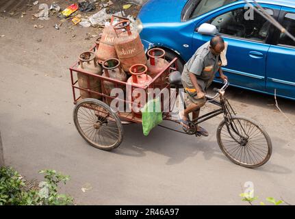 Howrah, Bengale-Occidental, Inde - 20 mars 2023 : un livreur indien transportant une bouteille GPL Indane dans sa camionnette de livraison Banque D'Images