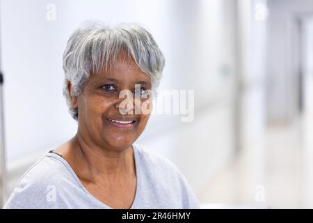Portrait non modifié d'une patiente biraciale âgée heureuse souriant à l'hôpital, avec espace de copie Banque D'Images