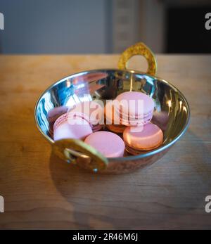Macarons roses sur une assiette dorée Banque D'Images
