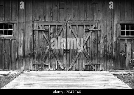 Une grange classique de style vintage avec deux grandes portes et fenêtres rectangulaires Banque D'Images
