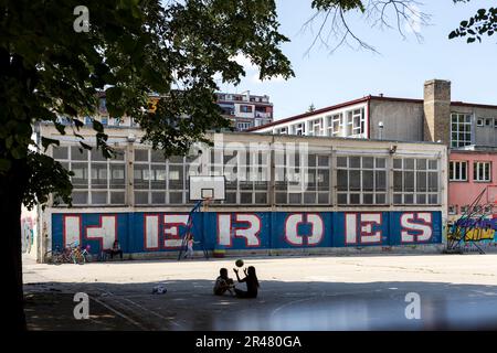 Belgrade, Serbie - 05-20-2023: Les enfants jouent sur un terrain de basket-ball avec des graffitis qui disent des héros Banque D'Images