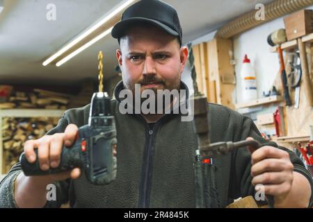 main d'homme tenant un tournevis sans fil avec fond de mur, charpentier  travaillant avec un tournevis électrique sur le travail 25498528 Photo de  stock chez Vecteezy