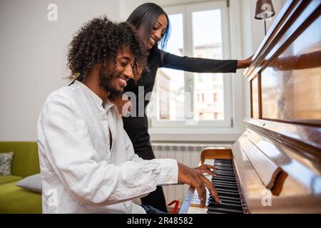 Un garçon joue un piano avec son ami et ils ont du plaisir, classe musicale Banque D'Images