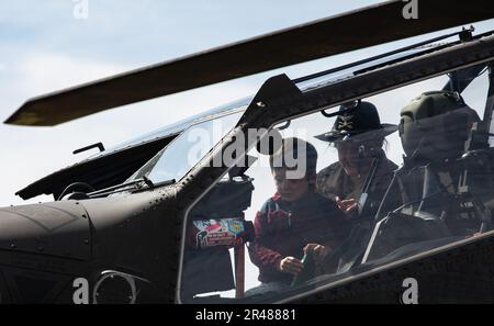 ÉTATS-UNIS L’Adjudant-chef de l’armée 2 Gabby Ulm, un pilote Apache affecté au 1st Escadron de reconnaissance d’attaque lourde, 6th Cavalry Regiment, 1st combat Aviation Brigade, 1st Infantry Division, donne un coup d’œil à un garçon à l’intérieur d’un hélicoptère AH-64 Apache lors d’une visite du musée Amelia Earhart Hanger à Atchison, Kansas, 7 mars 2023. Les soldats ont effectué un survol de vol entièrement féminin et ont visité le musée Amelia Earhart à Atchison, Kansas, pour célébrer les réalisations des femmes dans le domaine de l'aviation. Banque D'Images