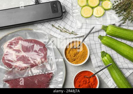 Composition de la couche plate de différents aliments, épices et scelleuse pour l'emballage sous vide sur la table Banque D'Images