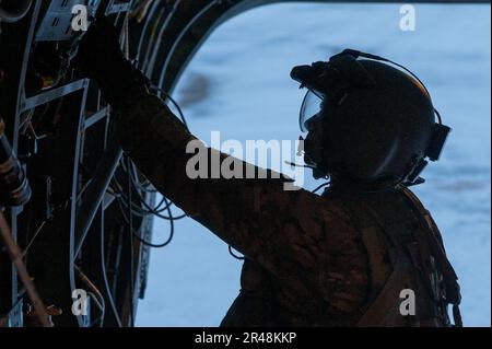 A ÉTATS-UNIS Un soldat de l'armée affecté à la Compagnie Bravo, 1st Bataillon, 52nd Aviation Regiment, prépare un CH-47 Chinook pour un assaut aérien lors du joint Pacific multinational Readiness Complex-Alaska 23-02 à l'aérodrome de l'armée de Ladd, ft. Wainwright, Alaska, 3 avril 2023. Le JPMRC-AK 23-02 aide les soldats et les dirigeants à élaborer et à affiner les tactiques, techniques et procédures nécessaires pour fonctionner avec succès dans des conditions d'hiver arctiques éloignées et extrêmes et pour surmonter les défis environnementaux et militaires. Banque D'Images