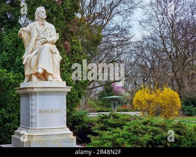 Statue en marbre du poète et écrivain autrichien Robert Hamerling assis dans une chaise dans le parc de la ville Stadtpark, à Graz, région de Steiermark, Autriche. Sél Banque D'Images