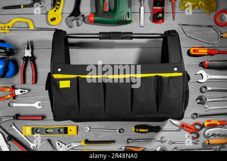 Composition de la pose plate avec sac et de nombreux outils différents sur table rustique en bois Banque D'Images