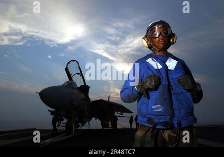 L'équipage du pont DE l'US Navy Flight à bord du porte-avions à propulsion nucléaire USS Abraham Lincoln (CVN 72), observe le coucher du soleil pendant qu'il attend le début des opérations du pont de vol de nuit Banque D'Images