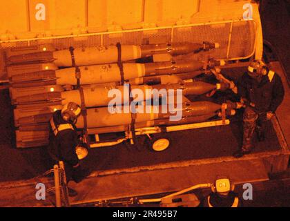 LES officiers DE l'aviation DE LA US Navy déplacent des bombes d'un ascenseur de pont de vol à l'avion Carrier Air Wing Eight (CVW-8) à bord du porte-avions USS Theodore Roosevelt (CVN 71) Banque D'Images