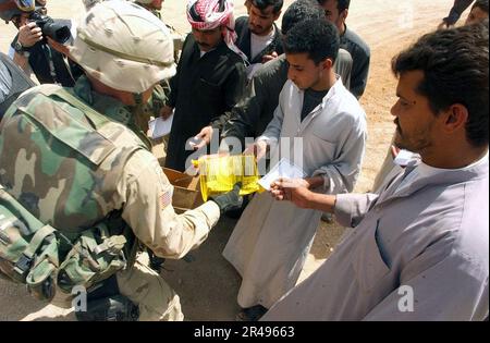 MARINE AMÉRICAINE Un parachutiste affecté à la division aéroportée de 82nd remet des rations humanitaires aux citoyens irakiens du centre de l'Irak Banque D'Images