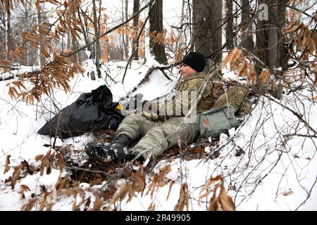 Le SPC Brandon Negrete, un medic affecté aux observateurs avant du 1-120th Field Artillery Regiment, réagit à une attaque simulée lors de la grève du Nord 23-1, le 24 janvier 2023, au Camp Grayling, au Michigan. Les unités qui participent à la phase d’hiver de la grève du Nord sont prêtes en menant une formation conjointe par temps froid conçue pour atteindre les objectifs de la Stratégie pour l’Arctique du ministère de la Défense. Banque D'Images