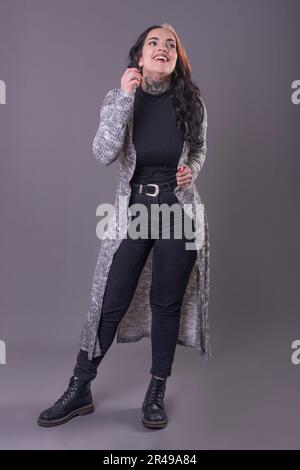 Portrait complet d'une femme attirante en décontracté sur fond gris. Prise de vue en studio Banque D'Images