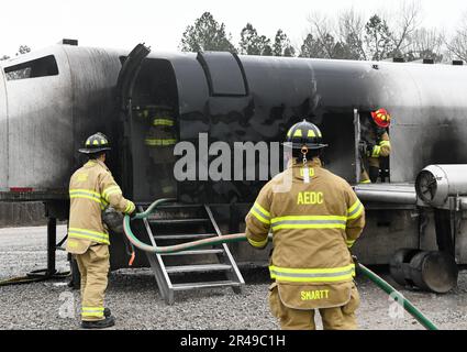 Le colonel Randel Gordon, à droite, Arnold Engineering Development Complex commandant, transporte un mannequin d'entraînement par une porte latérale d'un simulateur d'incendie d'avion à la base aérienne Arnold, au Tennessee, au 9 mars 2023. Devant le simulateur, Chevis Lee, pompier de la base aérienne Arnold, utilise une ligne de main pour combattre un incendie. Gordon a eu l'occasion de participer pour améliorer sa compréhension des compétences et des efforts nécessaires pour lutter contre le feu. Banque D'Images