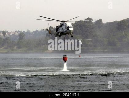 MARINE AMÉRICAINE deux hélicoptères SEA King UH-3H affectés à l'escadron de soutien au combat des Golden Gaters of Helicopter Eighty Five (HC-85) trempent leur seau Bambi dans un lac pour faciliter l'effort de lutte contre l'incendie Banque D'Images