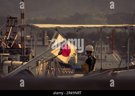 Capturant l'essence même du patrimoine maritime japonais, un garde maritime se dresse devant ses quais au port de Tsuruga. Le drapeau japonais surprenants Banque D'Images