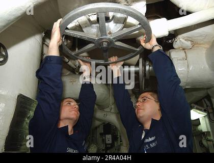 CÔTÉ gauche du machiniste Mate 2nd DE la Marine AMÉRICAINE et classe du machiniste Mate 1st, positionnez une vanne dans la salle des réacteurs deux Banque D'Images