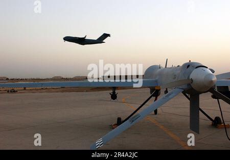 US Navy Un C-17 Globemaster III prend son envol de la base aérienne de Balad, en Irak, en tant que U.S. Le véhicule aérien sans pilote (UAV) de la Force aérienne MQ-1L est en attente de lancement Banque D'Images