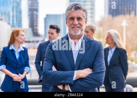 Un homme d'affaires caucasien en costume professionnel se tient devant un groupe d'hommes d'affaires Banque D'Images